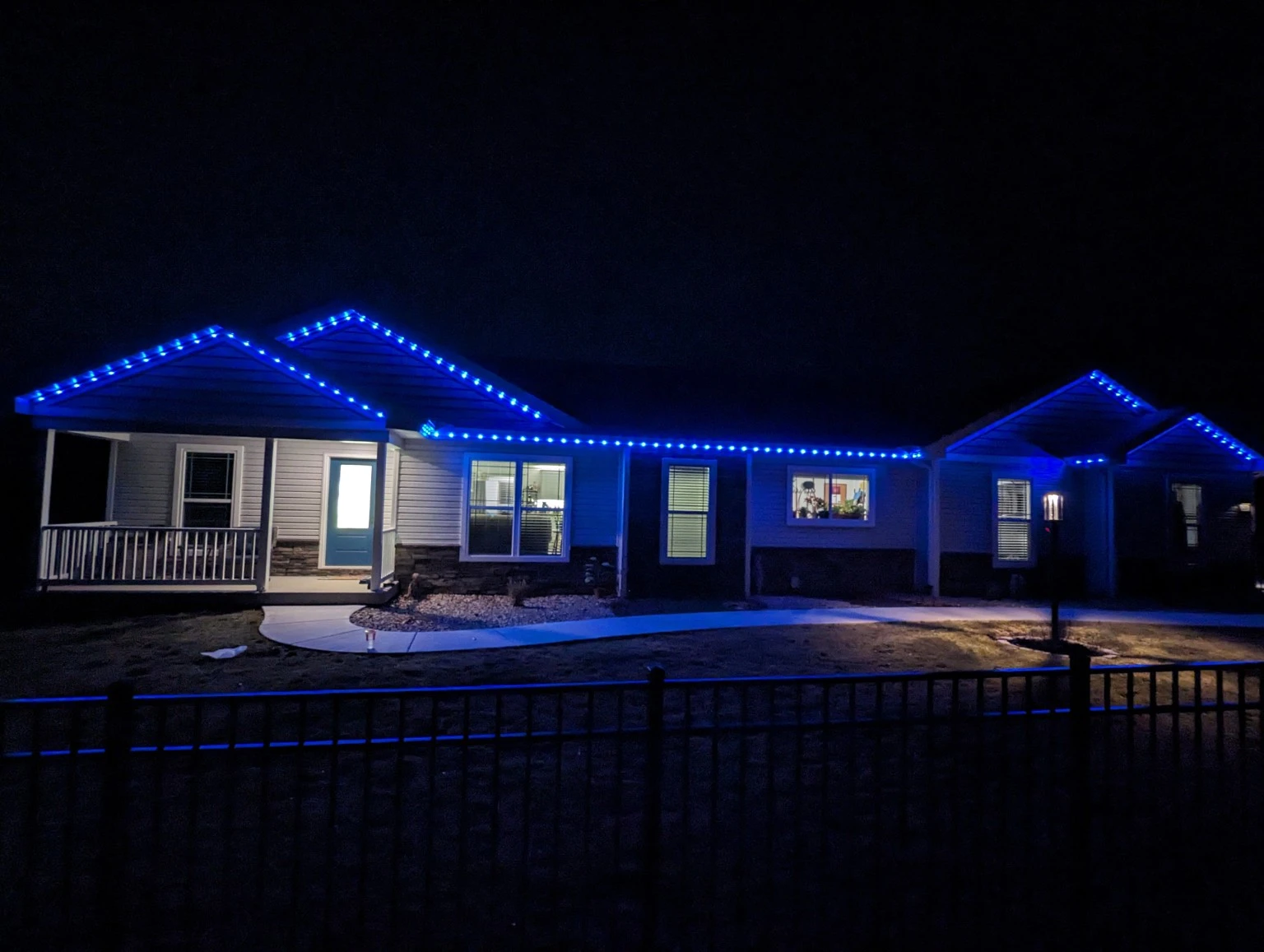 David's actual installation of blue permanent roofline lighting on a home at night